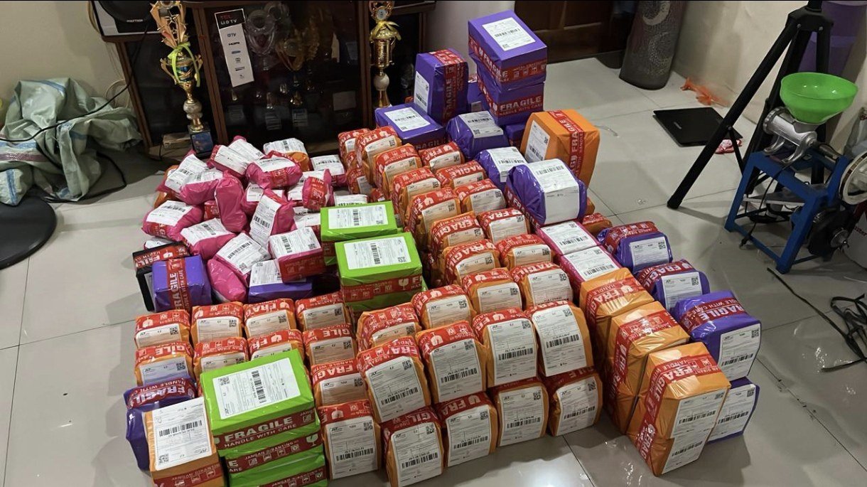 Tumpukan paket pesanan siap kirim di lantai gudang